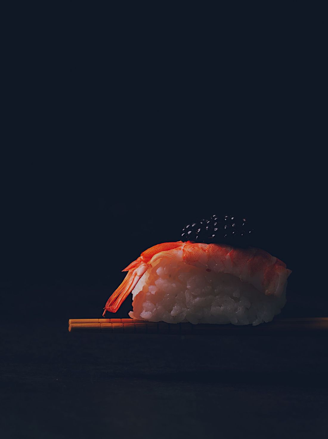 箸でつまんだ海老の握り